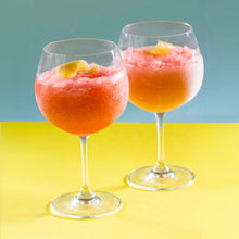 Load image into Gallery viewer, Two glasses of pink slushie with lemon slices on a yellow and blue background