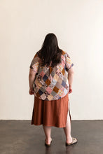 Load image into Gallery viewer, Person wearing a patchwork shirt and brown skirt against a white wall