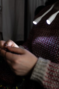person knitting using hoodie lights