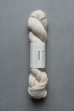 Load image into Gallery viewer, White skein of yarn with a label on a gray background