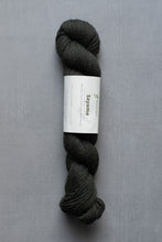 Load image into Gallery viewer, Dark gray skein of yarn with a label on a gray background