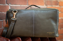 Load image into Gallery viewer, Green leather clutch bag with gold zipper and strap against a brick wall background