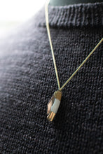 Load image into Gallery viewer, Necklace with a pendant on a dark textured fabric background