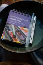 Load image into Gallery viewer, Watercolor pocket guide and markers on a dark surface