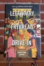 Load image into Gallery viewer, Book titled 'Legendary Frybread Drive-In: Intertribal Stories' on a stand with a brick wall background