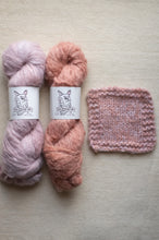 Load image into Gallery viewer, Two skeins of pink yarn with labels and a knitted swatch on a beige background