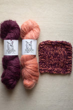 Load image into Gallery viewer, Two skeins of yarn in purple and pink with a knitted swatch on a beige background