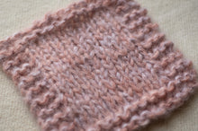 Load image into Gallery viewer, Close-up of a pink knitted fabric on a light green background