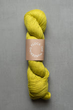 Load image into Gallery viewer, Yellow skein of yarn with a label on a gray background
