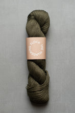 Load image into Gallery viewer, Green skein of yarn with a label on a gray background
