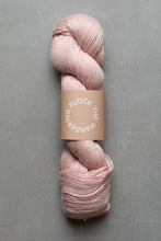 Load image into Gallery viewer, Pink skein of yarn with a label on a gray background