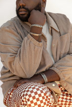 Load image into Gallery viewer, Man wearing a beige corduroy jacket and patterned pants with a white background