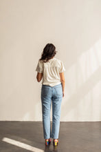Load image into Gallery viewer, Person wearing a white shirt and blue jeans standing against a plain wall.