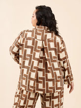 Load image into Gallery viewer, Person wearing a brown and beige geometric patterned outfit on a beige background