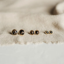 Load image into Gallery viewer, Pair of gold earrings with gemstones on a beige fabric background