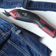 Red and black tool on a white background with blue jeans.