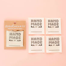 Load image into Gallery viewer, Set of 'Hand Made by' labels with a packaging card on a pink background