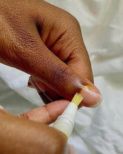 Load image into Gallery viewer, Hand applying a small amount of cream to a finger with a white tube.