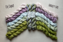 Load image into Gallery viewer, Four skeins of twisted wool yarn arranged in a fan shape on a light beige fabric background. The yarn colors are pastel pink, lavender, light blue, and olive green, with two white labels in the center reading 'SILKY CRAFT YARN'.