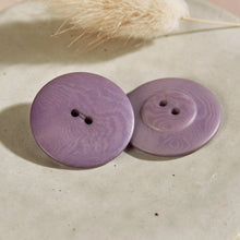 Load image into Gallery viewer, Two purple buttons on a textured surface with dried grass in the background