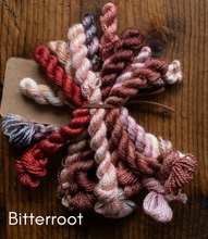 Load image into Gallery viewer, Color swatch of yarn with 'Bitterroot' label on a wooden surface