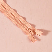 Load image into Gallery viewer, Close-up of a rose gold zipper on a matching pink background