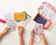 Load image into Gallery viewer, Children engaged in a craft activity with colorful templates and yarn on a white surface.
