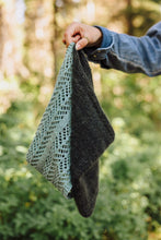 Load image into Gallery viewer, Person holding a knitted green and gray shawl against a blurred forest background