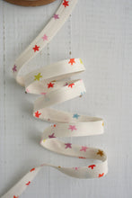 Load image into Gallery viewer, Decorative ribbon with colorful star patterns on a light wooden background