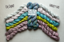 Load image into Gallery viewer, Four skeins of twisted yarn arranged in a fan shape on a light beige fabric background. The yarn colors are light pink, teal blue, lime green, and dusty mauve, with two skeins in the center featuring blue, purple, and green variegated stripes.