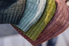 Load image into Gallery viewer, Stack of colorful knitted hats with a blurred background