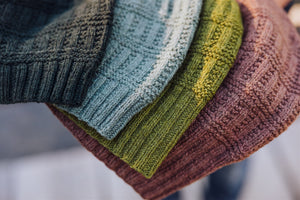 Stack of colorful knitted hats with a blurred background