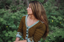 Load image into Gallery viewer, Woman wearing a brown cardigan with floral patterns in a forest setting