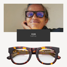 Load image into Gallery viewer, Person wearing tortoiseshell glasses with 'D28' branding, set against a plain background.
