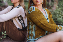 Load image into Gallery viewer, Two women sitting outdoors wearing patterned sweaters.