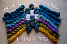 Load image into Gallery viewer, Colorful yarn skeins on a wooden surface with text labels.