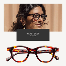 Load image into Gallery viewer, Tortoiseshell glasses with 'Wabi Sabi' branding displayed below a person wearing the glasses.