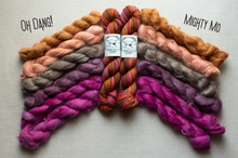 Load image into Gallery viewer, Four skeins of yarn arranged in a fan shape on a light gray background, with two braided bundles in the center and two twisted bundles flanking them. The yarn colors range from tan and peach to gray, purple, and magenta, with orange and red variegated stripes in the center skein.