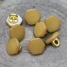 Load image into Gallery viewer, Set of mustard yellow hexagonal buttons with gold metal components on a gray surface