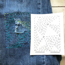 Load image into Gallery viewer, Embroidered design on denim fabric with a pattern guide next to it.