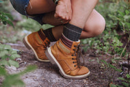 Person wearing brown hiking boots in a natural setting