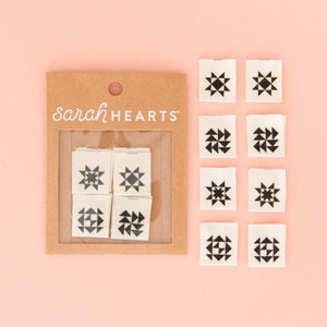 Set of black geometric star stamps on white paper with 'sarah HEARTS' branding on a pink background