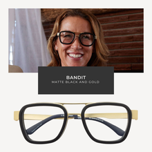 Load image into Gallery viewer, Woman wearing black and gold eyeglasses with 'Bandit' branding, set against a blurred indoor background.