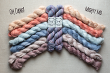 Load image into Gallery viewer, Six skeins of twisted yarn arranged in a fan shape on a light beige fabric background. The yarn colors include peach, light blue, dusty blue, lavender, mauve, and pale pink.
