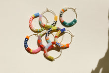 Load image into Gallery viewer, Colorful beaded hoop earrings on a beige background