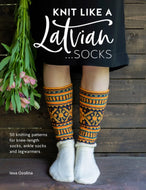 Book cover of 'Knit Like a Latvian... Socks' with a person wearing patterned socks against a wooden background.