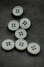Load image into Gallery viewer, White buttons with four holes on a textured gray surface