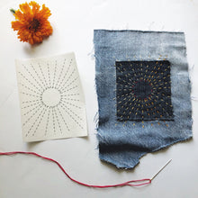 Load image into Gallery viewer, Denim patch with embroidered design on a white surface with an orange flower.