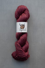 Load image into Gallery viewer, Burgundy skein of yarn with a label on a gray background