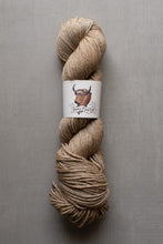 Load image into Gallery viewer, Ball of beige yarn with a label on a gray background